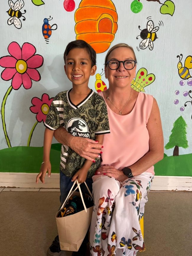 A Toddies pupil with principal Hendrene by the classroom mural